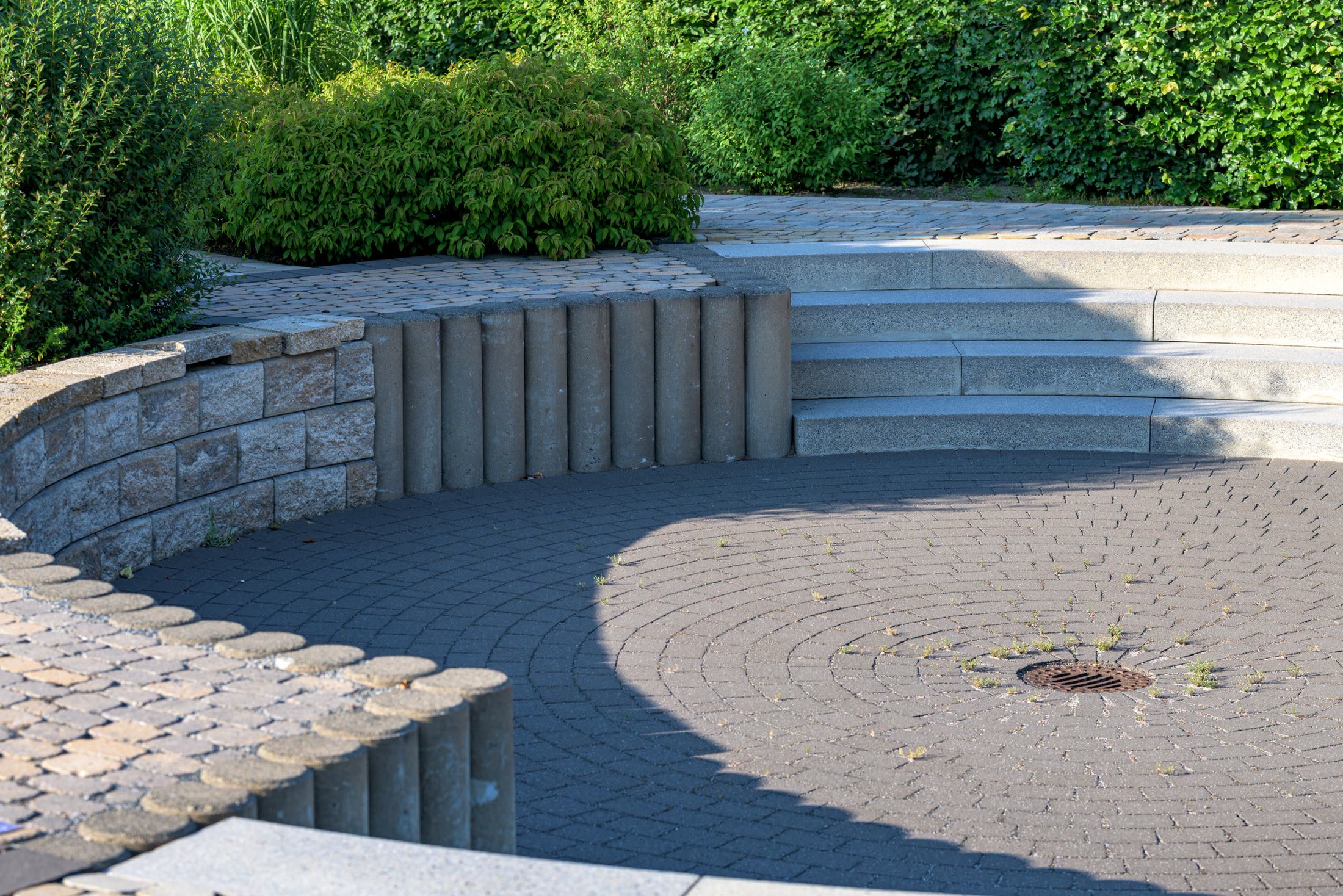 A beautifully landscaped garden with a stone patio, steps and lush planting